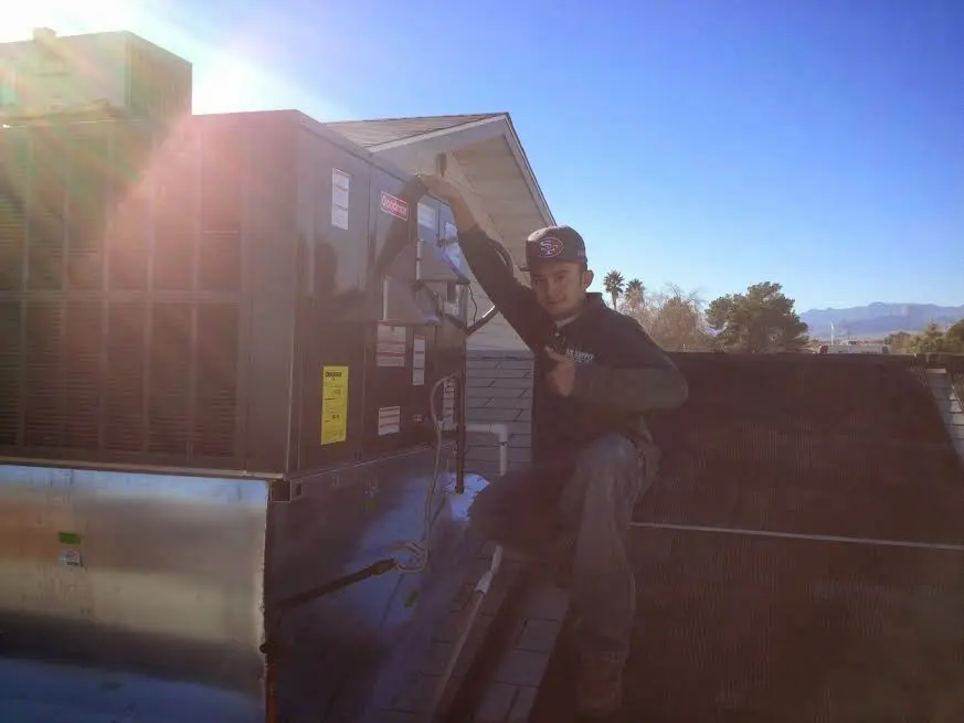 HVAC technician performing Air Duct Repair on a rooftop unit in Seward